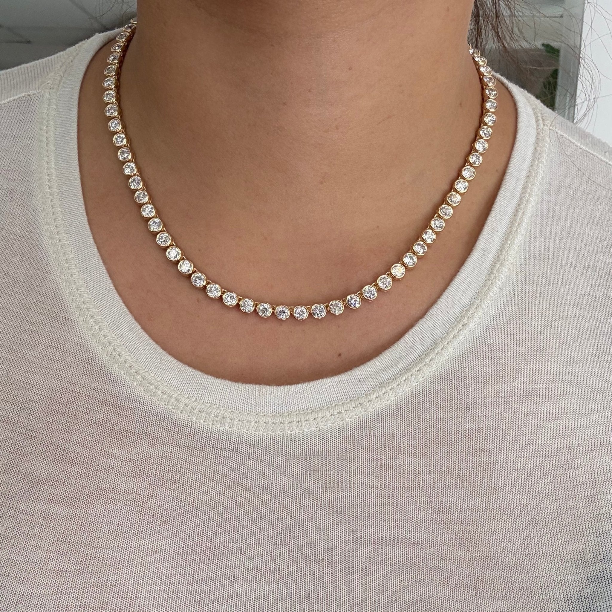 Full view of vintage-style diamond tennis necklace on model. Old European cut diamond necklace sparkling in natural sunlight