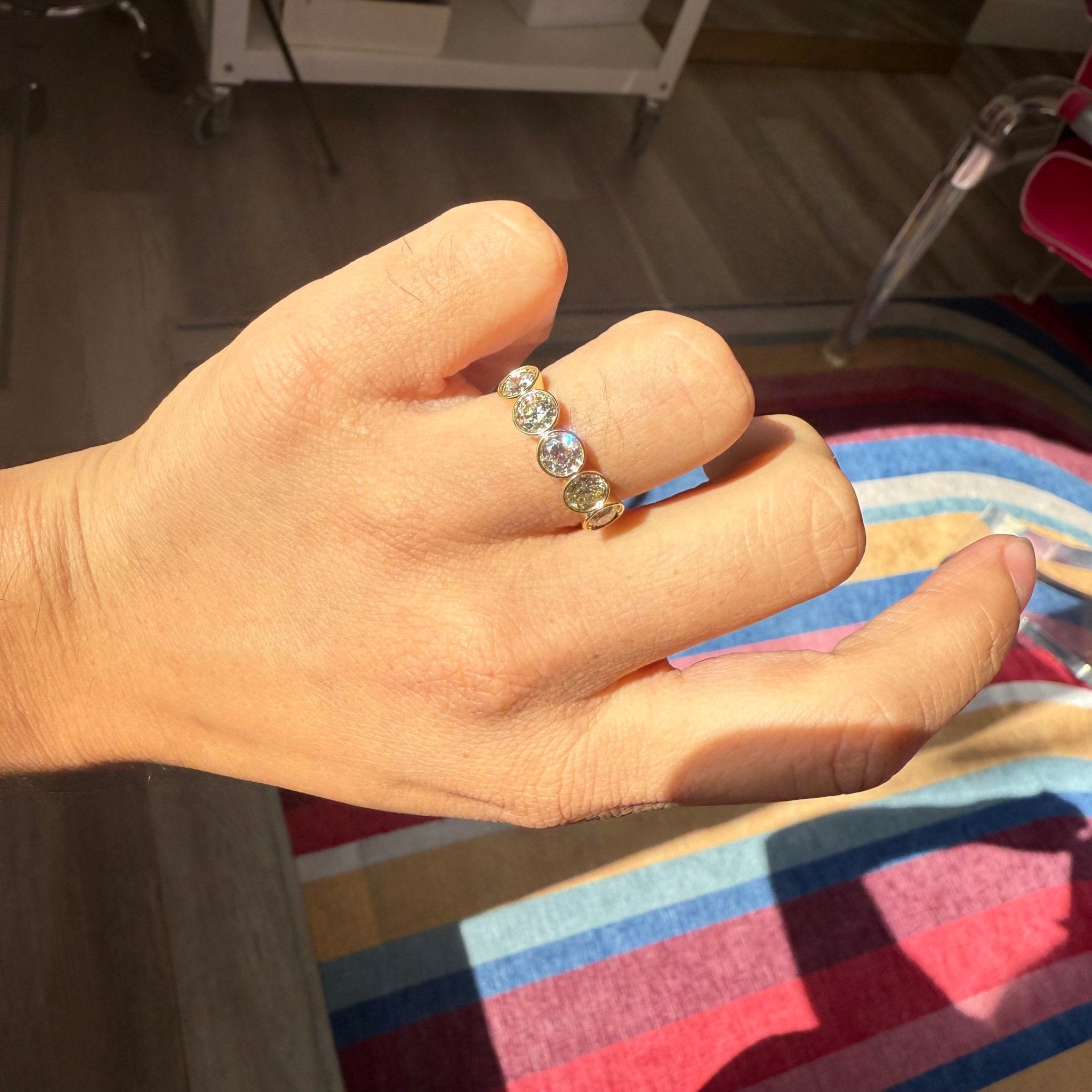 Old European cut diamonds in sleek bezel five-stone ring shown on hand