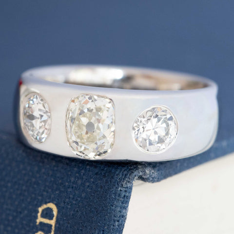 Old cut diamond three-stone ring, center stone flanked by antique cuts