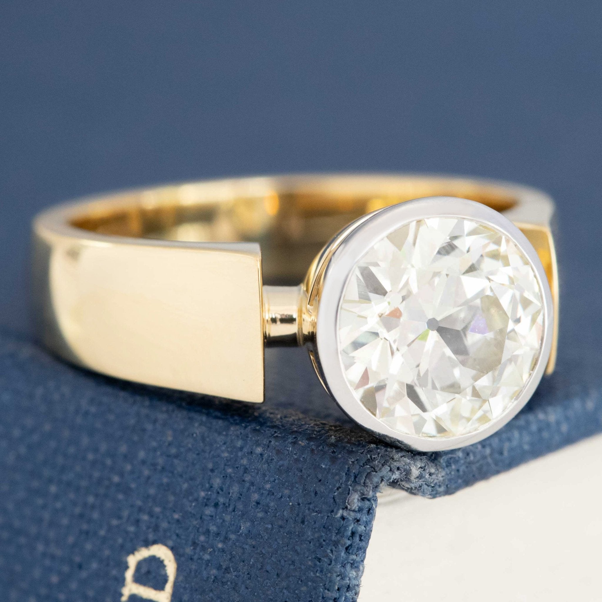 Antique style bezel diamond ring with warm gold band