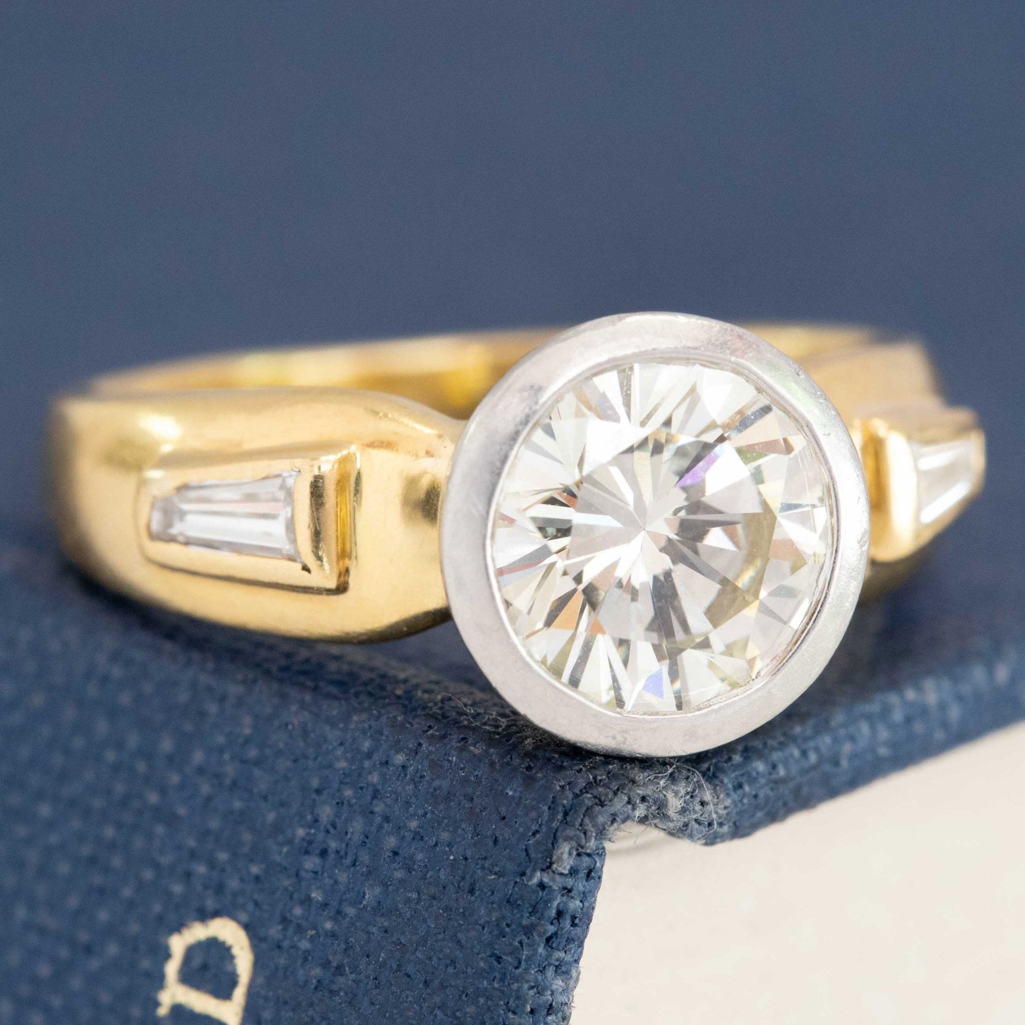 Bezel-set round diamond engagement ring with baguette band