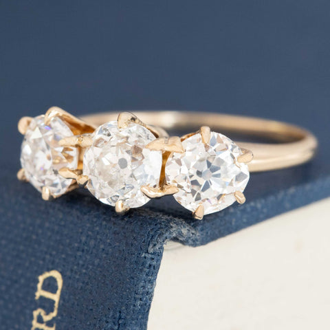 A antique 3-stone ring set with chunky old mine cut diamonds in a rosy yellow gold.  Perfect vintage engagement ring choice.