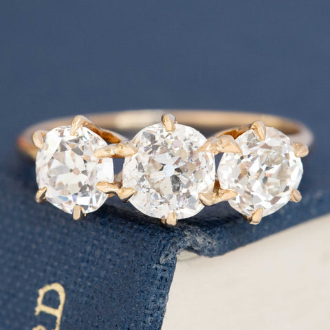 A antique 3-stone ring set with chunky old mine cut diamonds in a rosy yellow gold.  Perfect vintage engagement ring choice,
