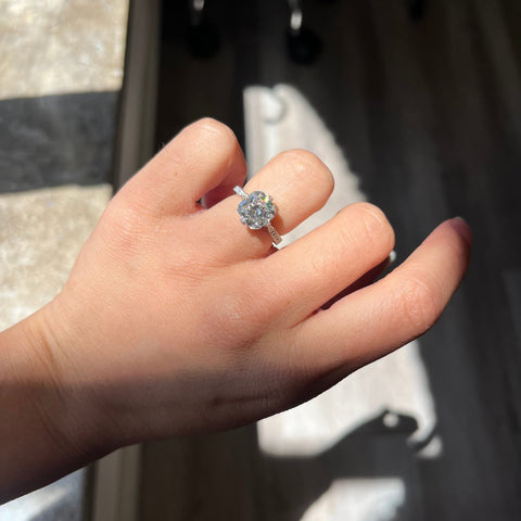 Antique-inspired platinum diamond ring with radiant cut center stone shown on ring finger