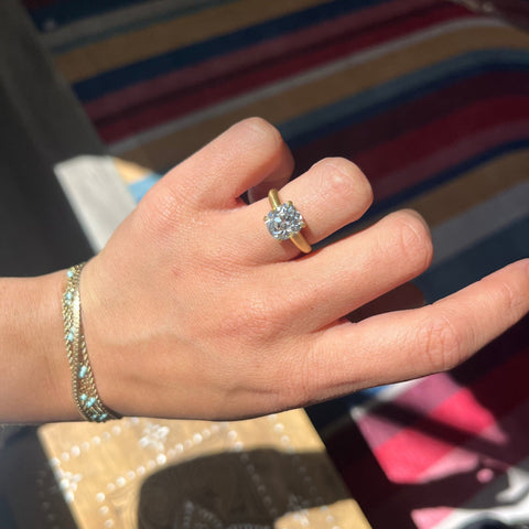 Classic yellow gold Old Mine Cut diamond engagement ring shown on finger