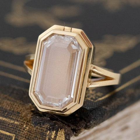 Antique-inspired portrait cut diamond ring with sliding locket mechanism.