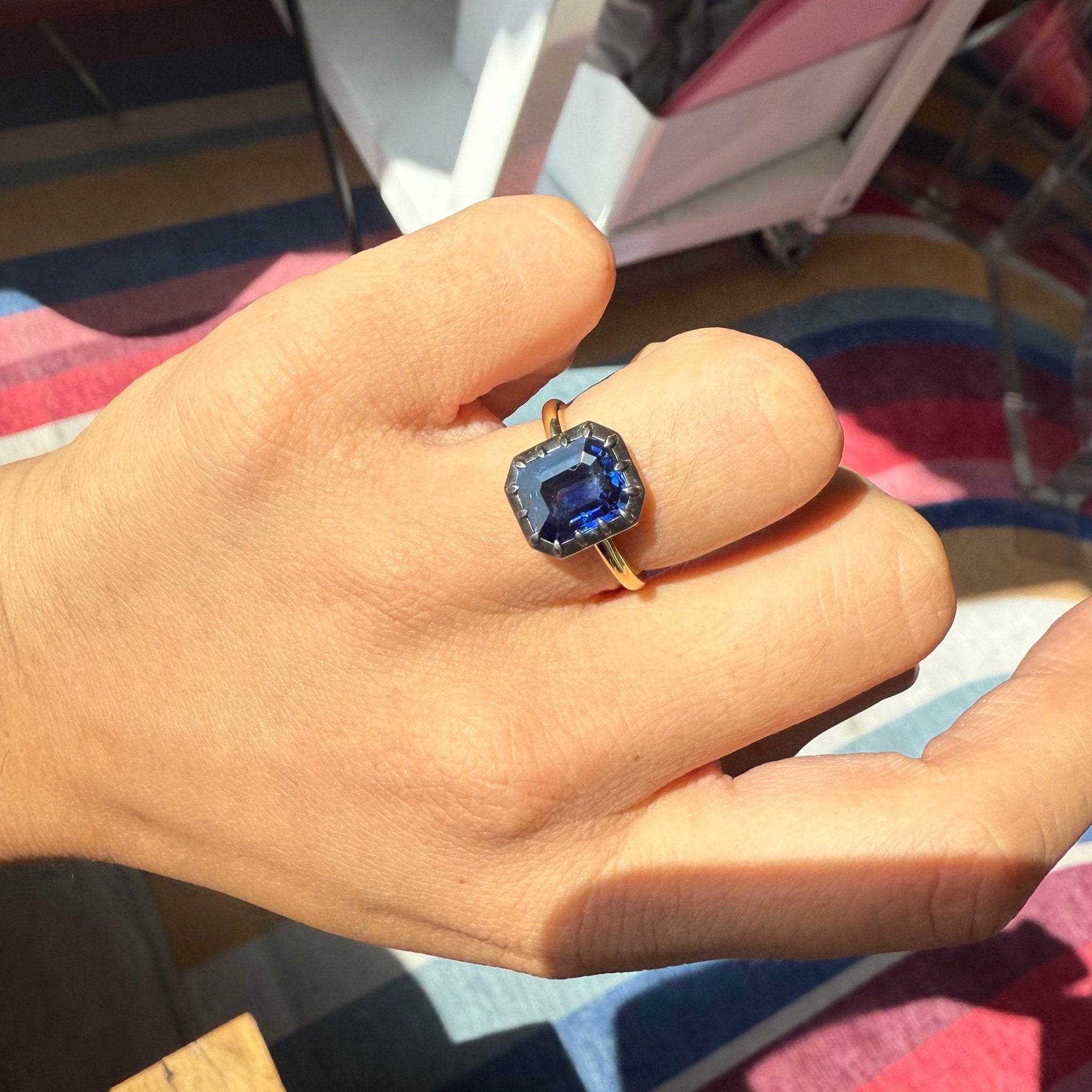 Hand shot view and Top-down of the deep blue, velvety Ceylon sapphire solitaire ring