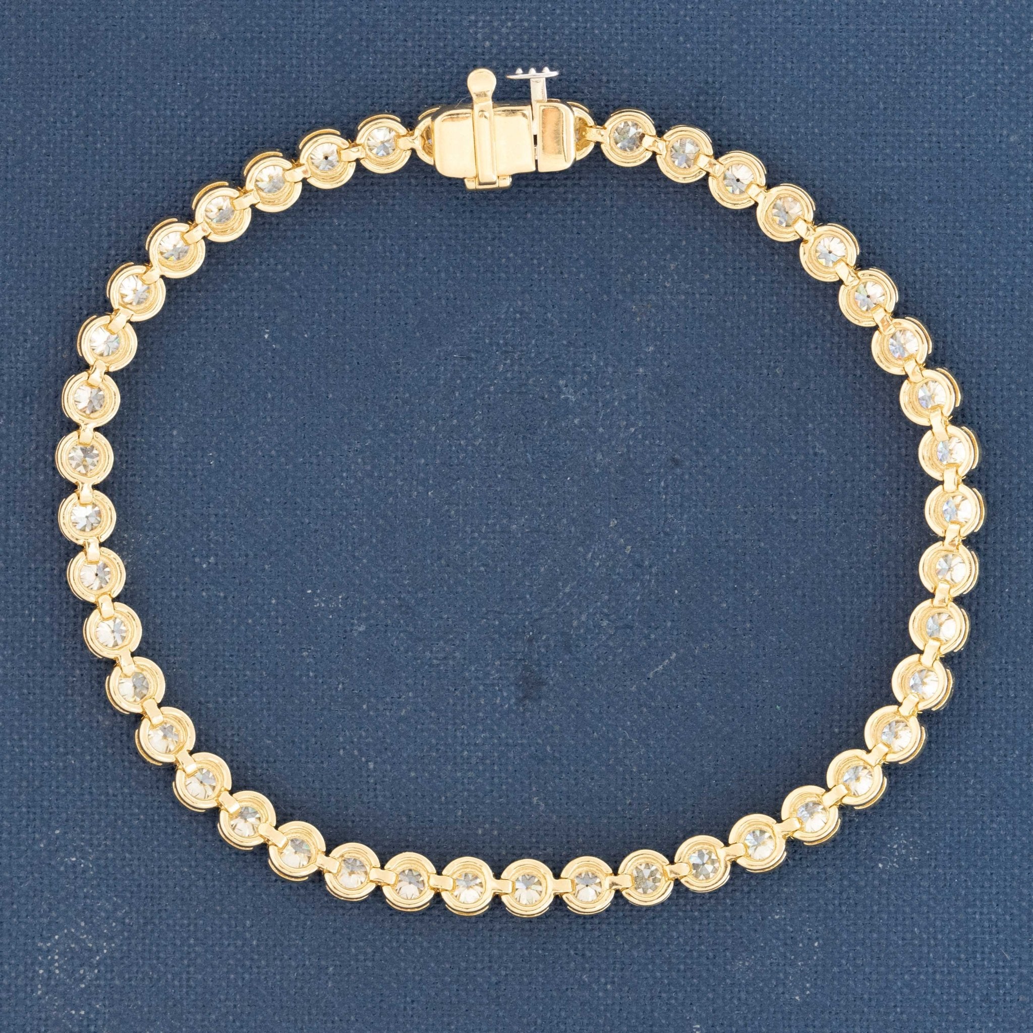 Close-up of antique Old European cut diamonds bezel-set in yellow gold. Detail of fiery diamond faceting and open culets in 18kt yellow gold bezels