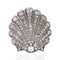 A scallop-shaped silver brooch paved with clear round gemstones, shown on a white background with a soft reflection below.