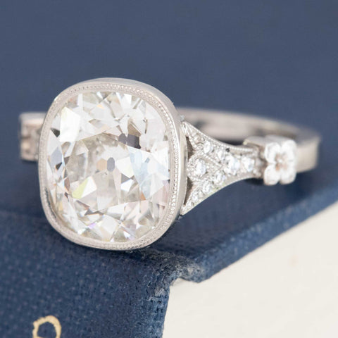 Custom antique 4ct Old Mine Cut diamond solitaire in yellow gold with bezel detail.