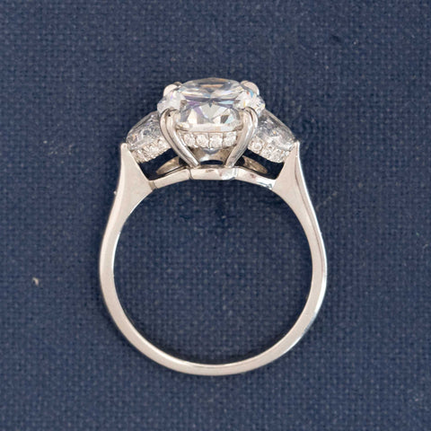 Oval diamond ring for collectors — classic platinum and half moon accents.