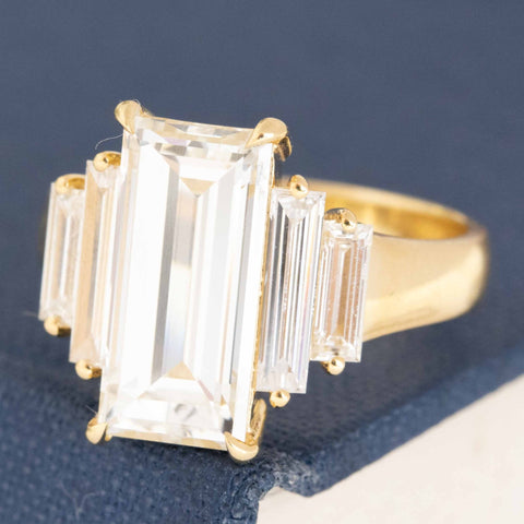 Elongated baguette diamond ring in yellow gold with antique side stones.