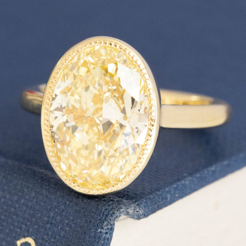 Yellow gold bezel setting with 4.70ct Fancy Yellow Diamond.