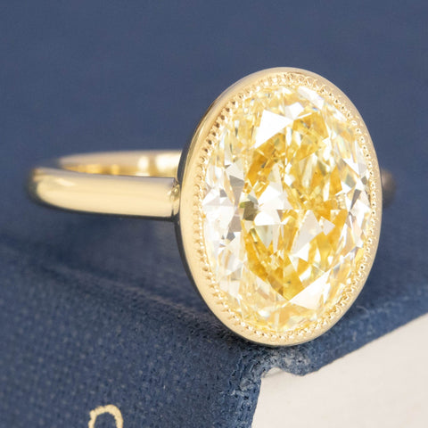 Elegant Fancy Yellow diamond solitaire, oval cut, VS2 clarity.
