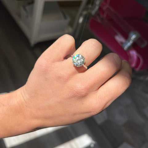 Antique platinum diamond ring featuring 4.93ct Old European Cut center stone shown on model.