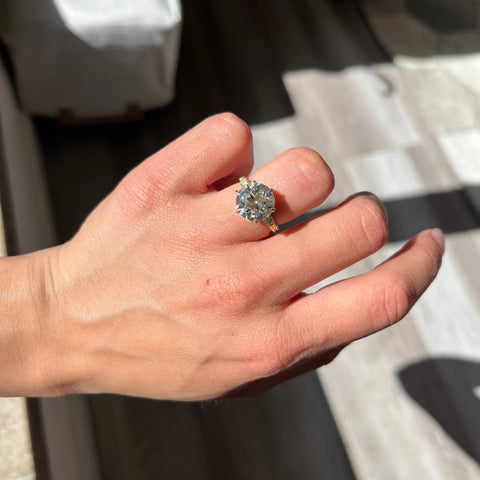 Elegant antique-inspired 18kt yellow gold transitional cut diamond ring on model. Bright and prismatic transitional diamond ring in yellow gold.