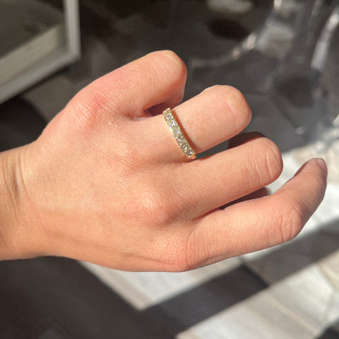 Elegant .65ctw French Cut Diamond Half-Hoop Bezel Band, romantic design with French Cut Diamonds, Earth-mined diamonds in yellow gold shown on ring finger