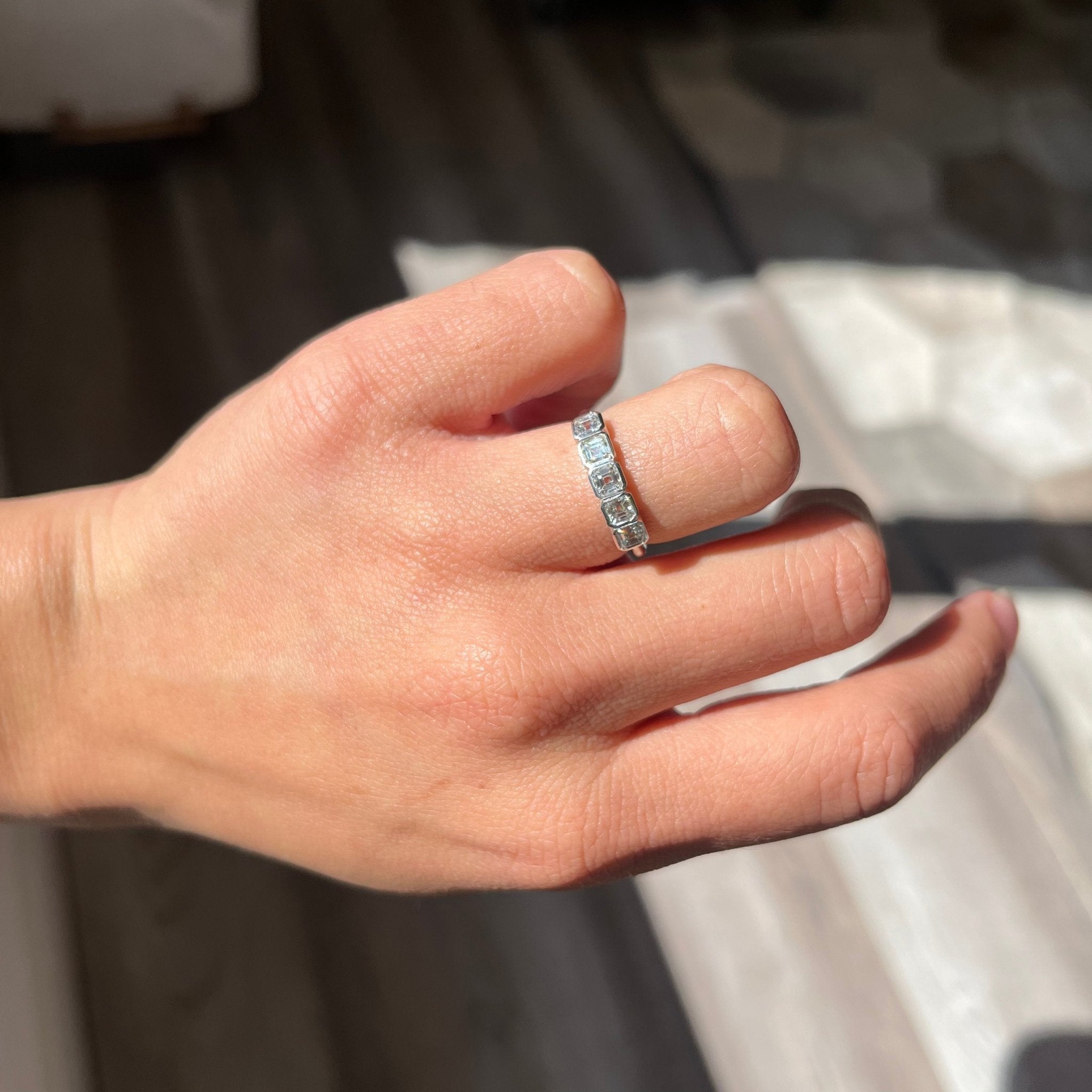 Elegant .73ctw Asscher Cut Diamond Bezel 5-Stone Band, romantic design with Antique Diamonds, Earth-mined diamonds in platinum shown on ring finger