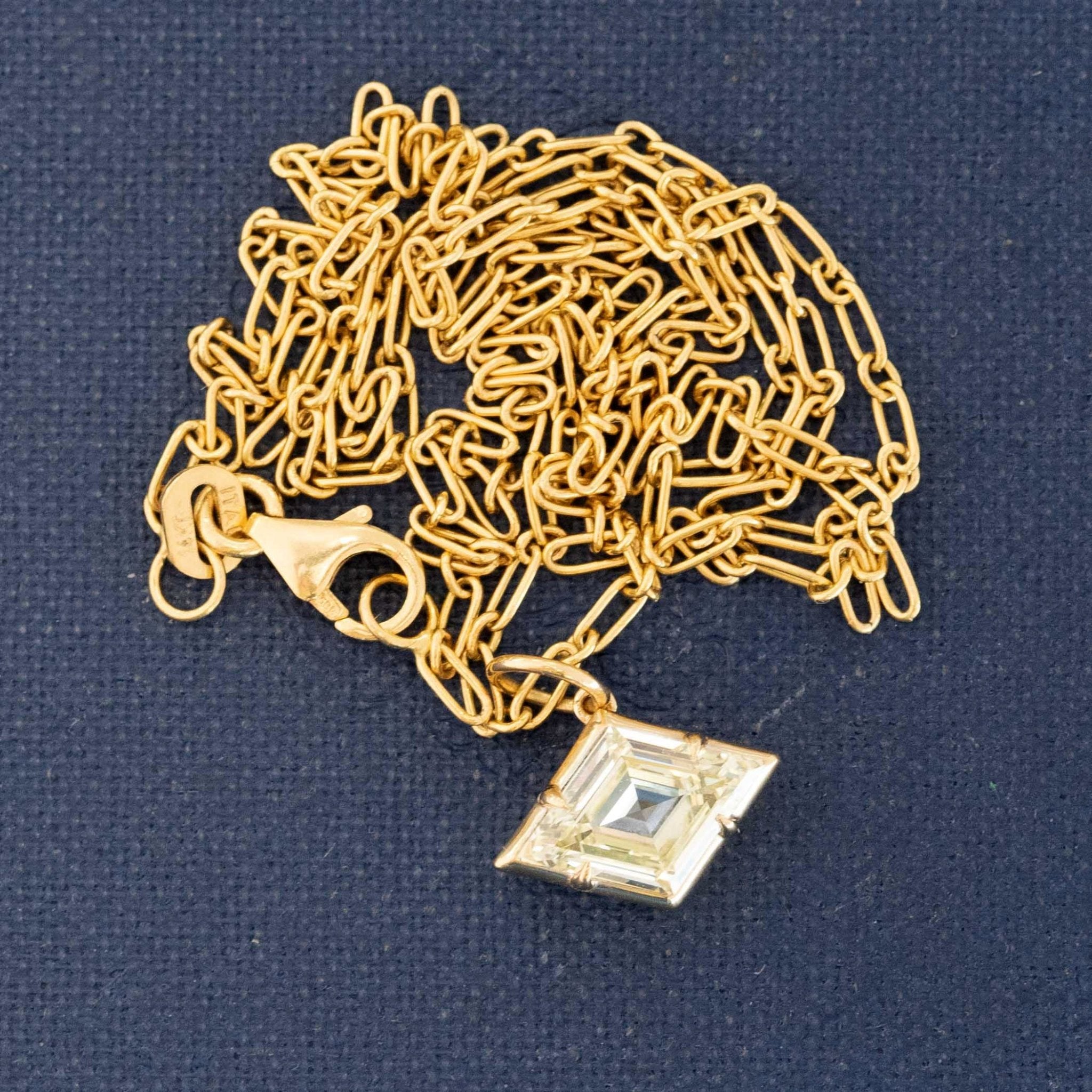.91-carat kite cut diamond pendant in white gold laying on dark background