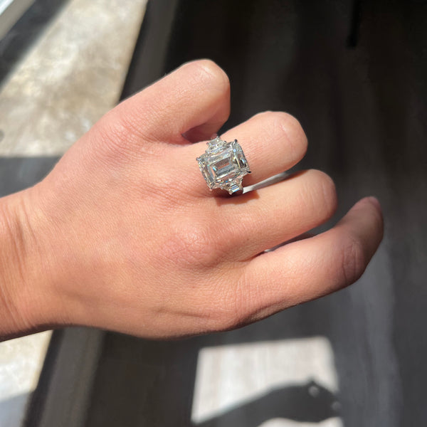 Cushion Cut Diamond Trilogy Ring on a finger