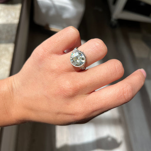 Antique Edwardian diamond ring with intricate airy setting and Old European cut accents on model.