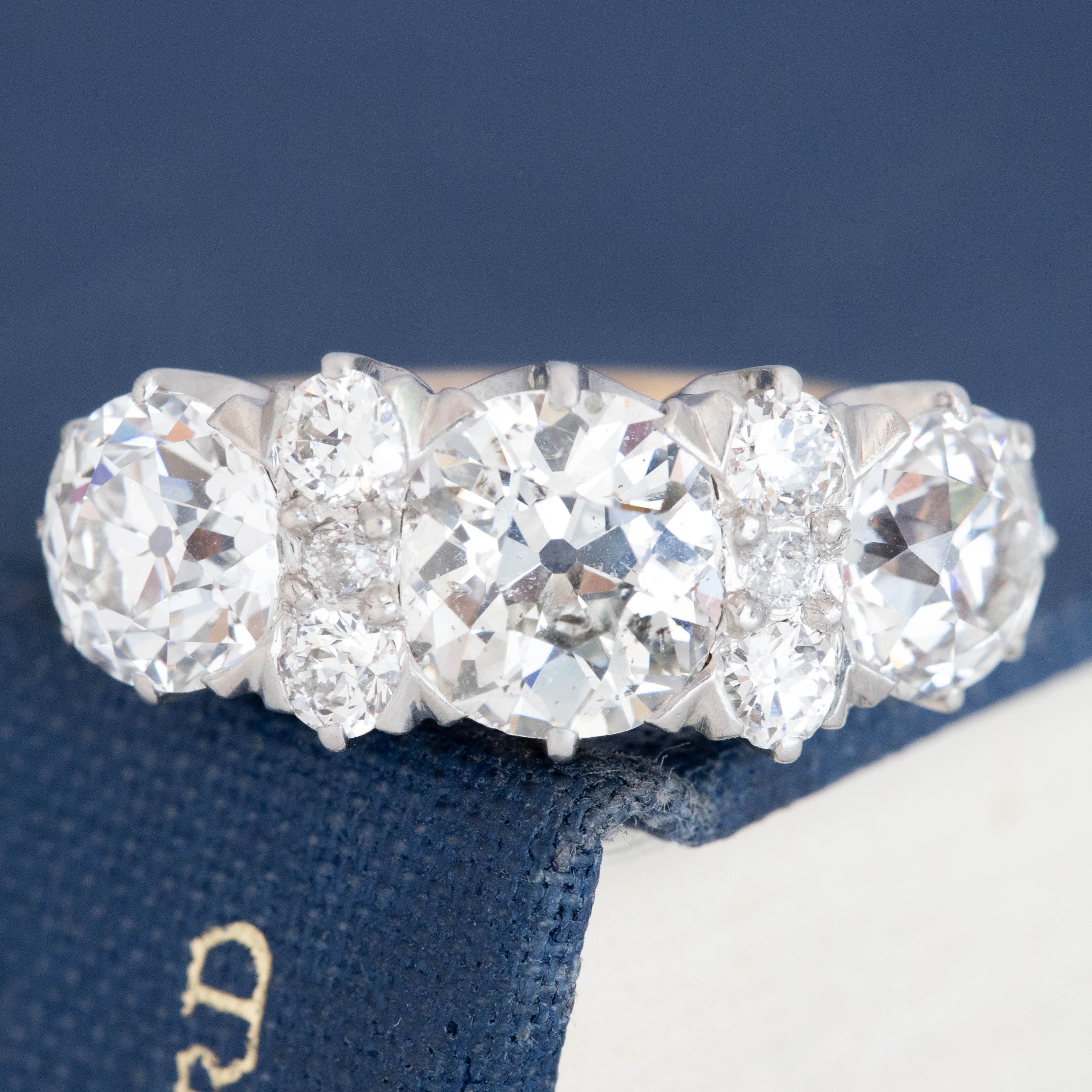 Antique Edwardian five-stone diamond ring with old mine cut diamonds in two-tone gold