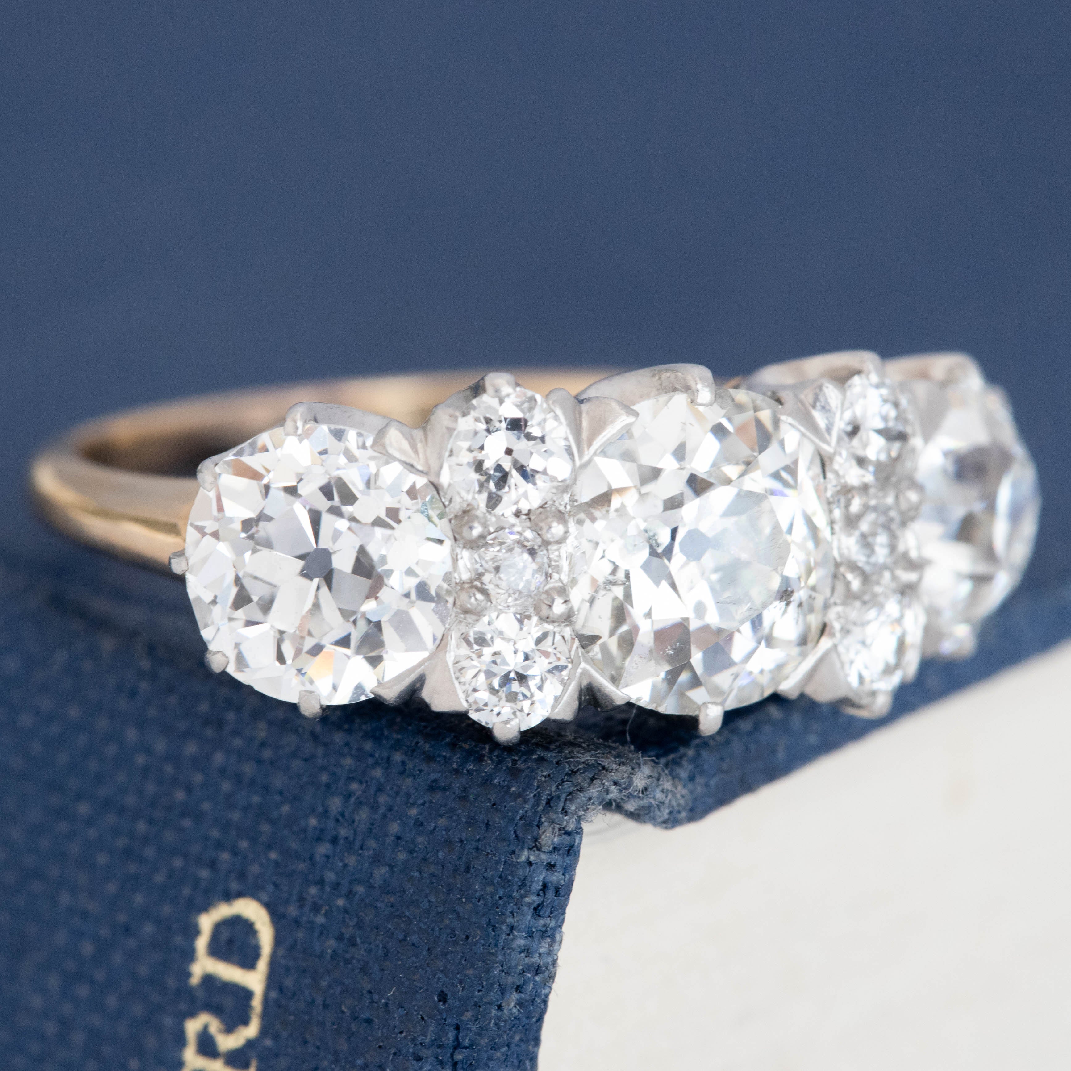 Antique five-stone diamond engagement ring with diamond spacers and claw prongs