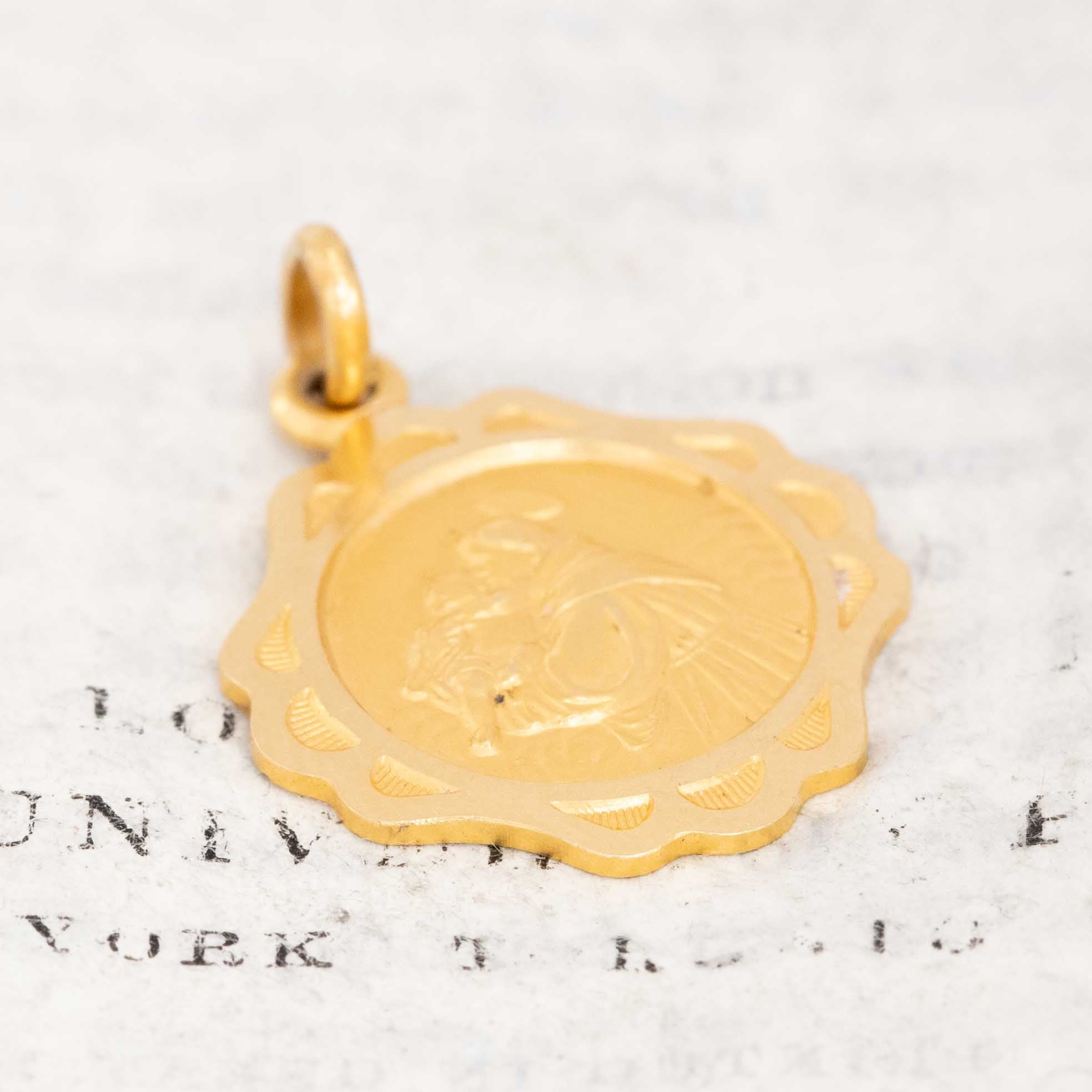 Close-up of antique-style St. Anthony medal in gold