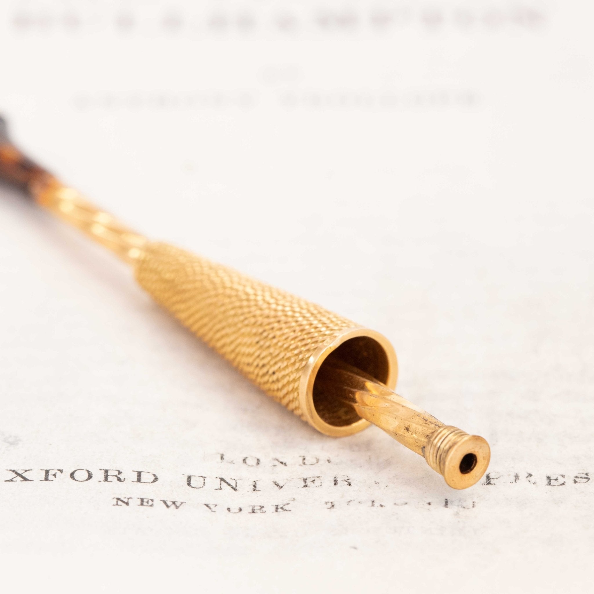Detailed close-up of textured gold French cigar holder, early 1900s design