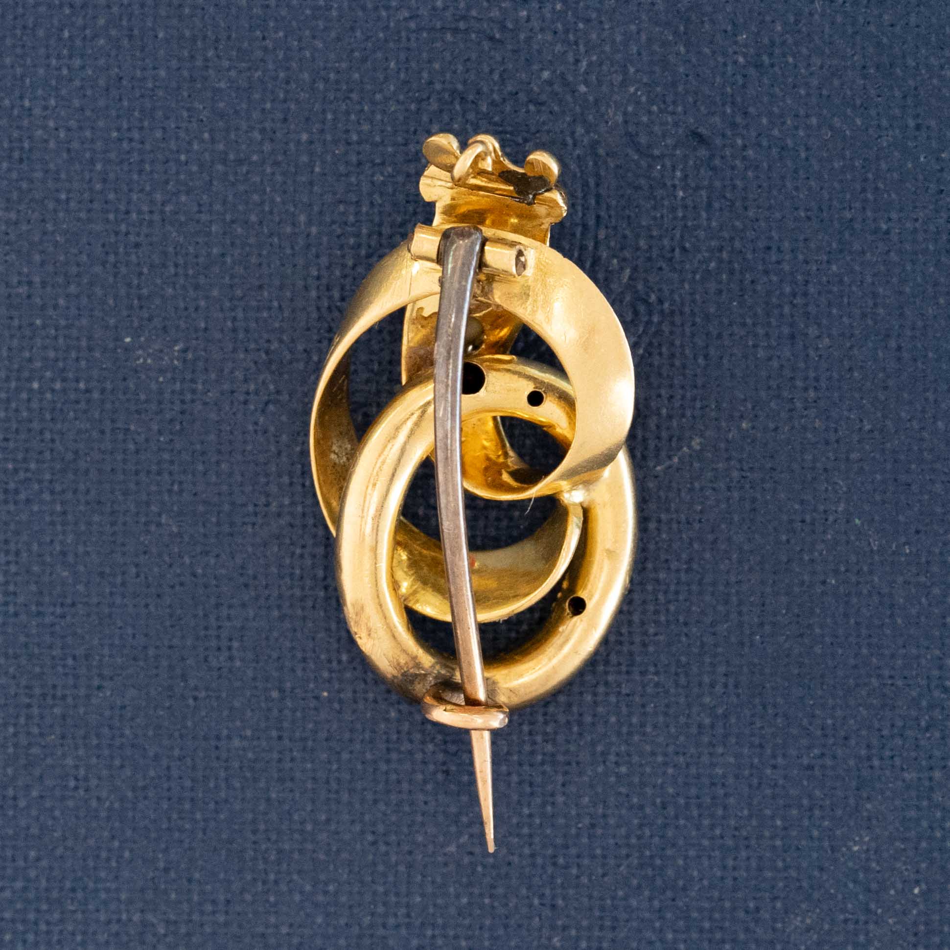 Victorian antique crowned serpent brooch in engraved gold with deep blue enamel, set with a diamond and seed pearl, symbolizing eternal love and triumph.