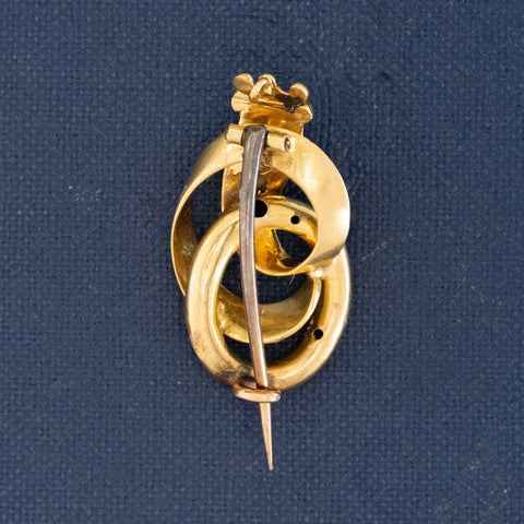 Victorian antique crowned serpent brooch in engraved gold with deep blue enamel, set with a diamond and seed pearl, symbolizing eternal love and triumph.
