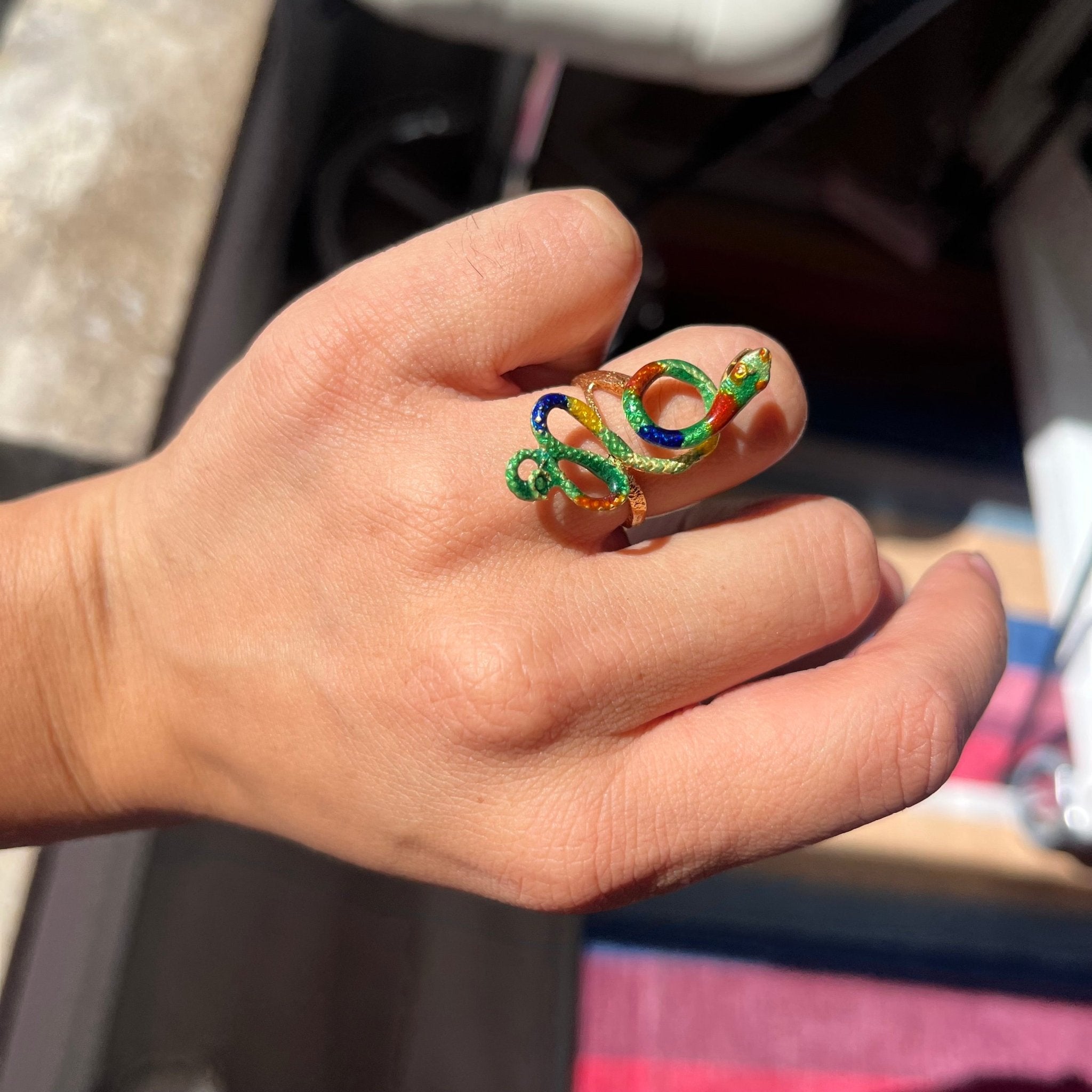 Close-up of antique enamel snake ring with colorful detailing and textured gold