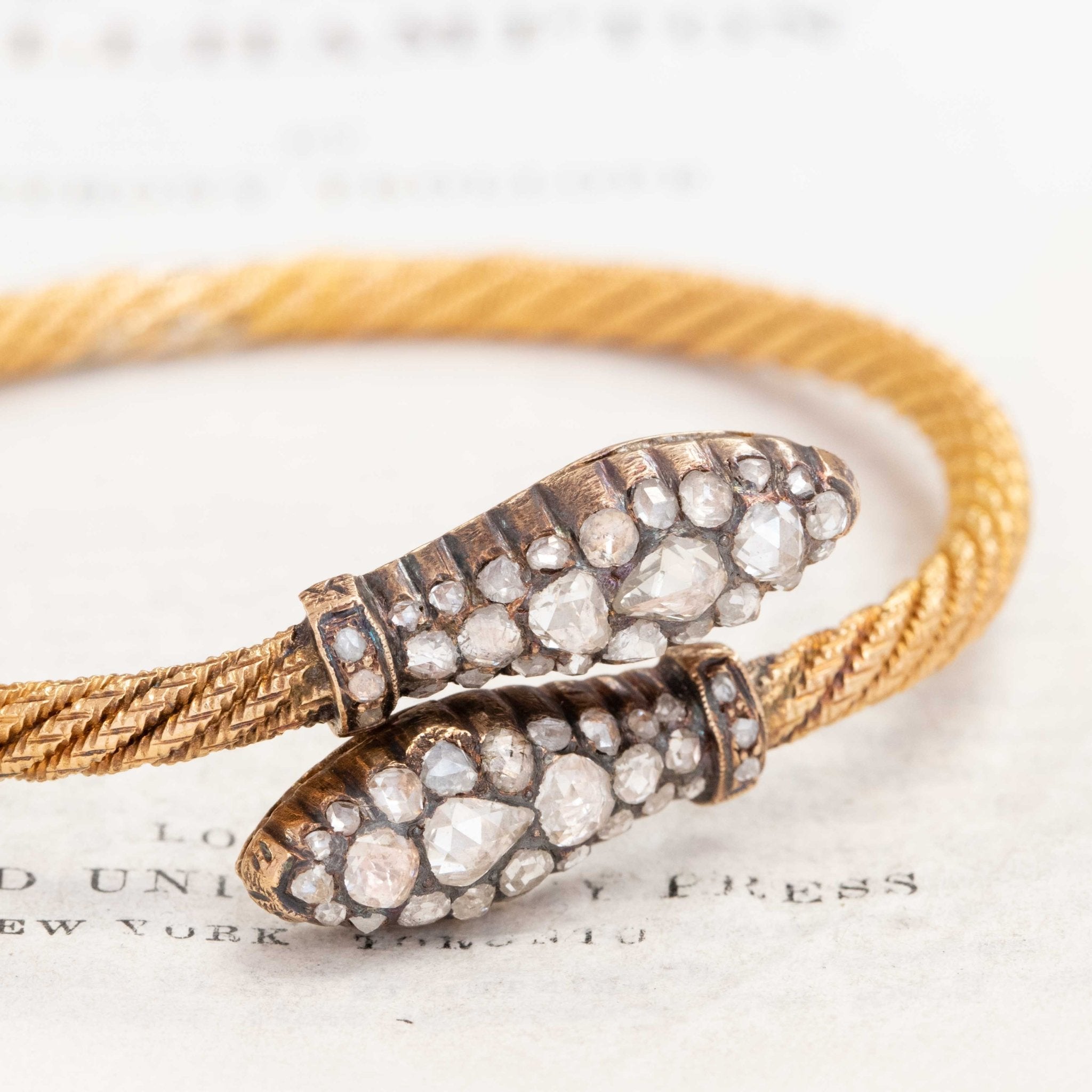 Collectible antique serpent motif bangle in gold with rose-cut diamonds, symbolic of eternity and protection.
