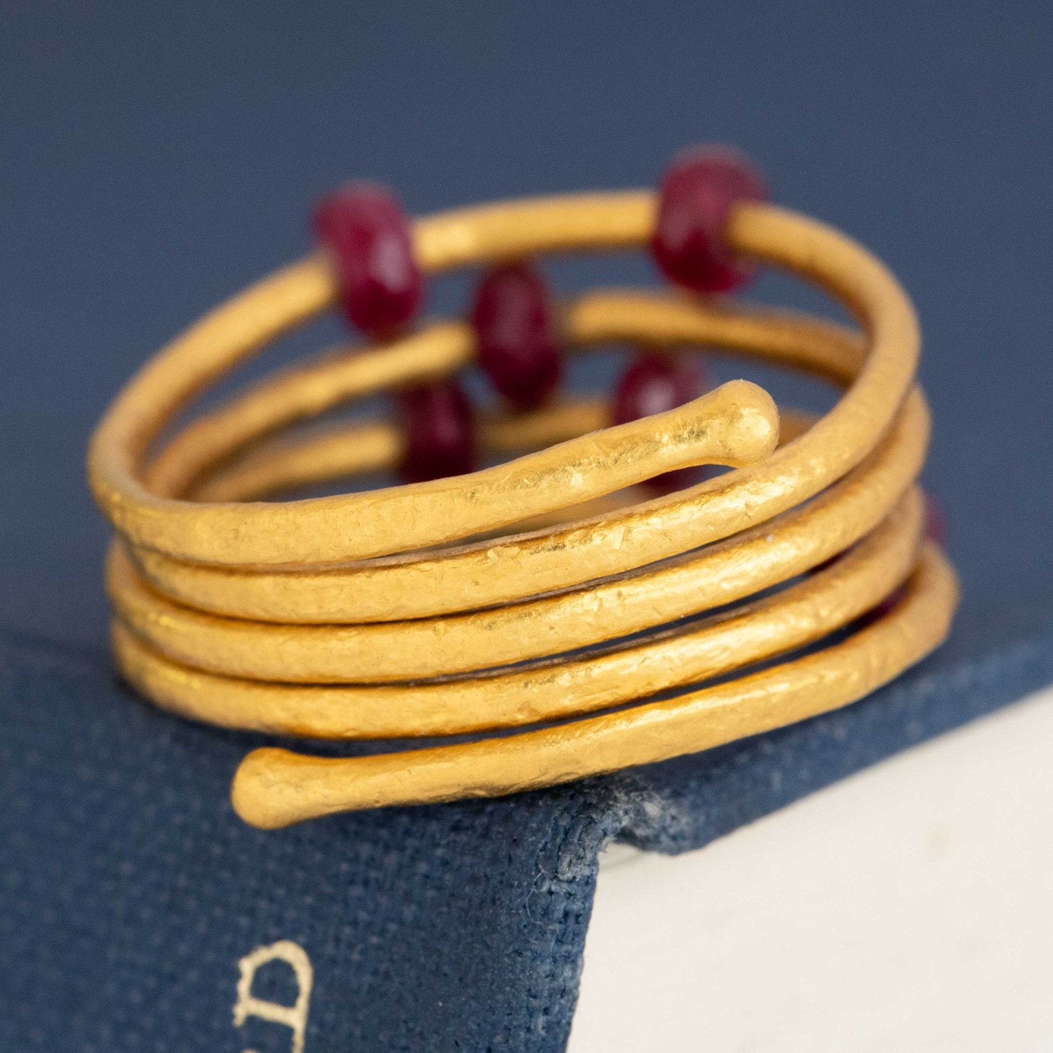 Designer ruby ring in 24k yellow gold by Gurhan – unique coiled band with gemstone details