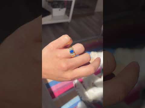 video showing top view of sapphire center flanked by two baguette diamond side stones in vintage style on the finger