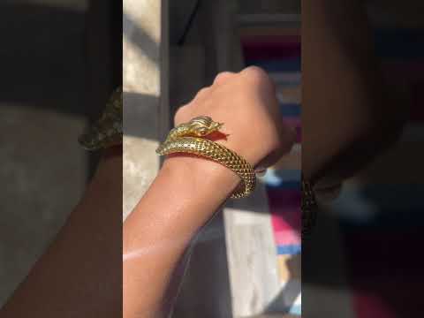 A beautiful vintage serpent themed bracelet with beautiful, realistic texture in rich yellow gold and ruby eyes.