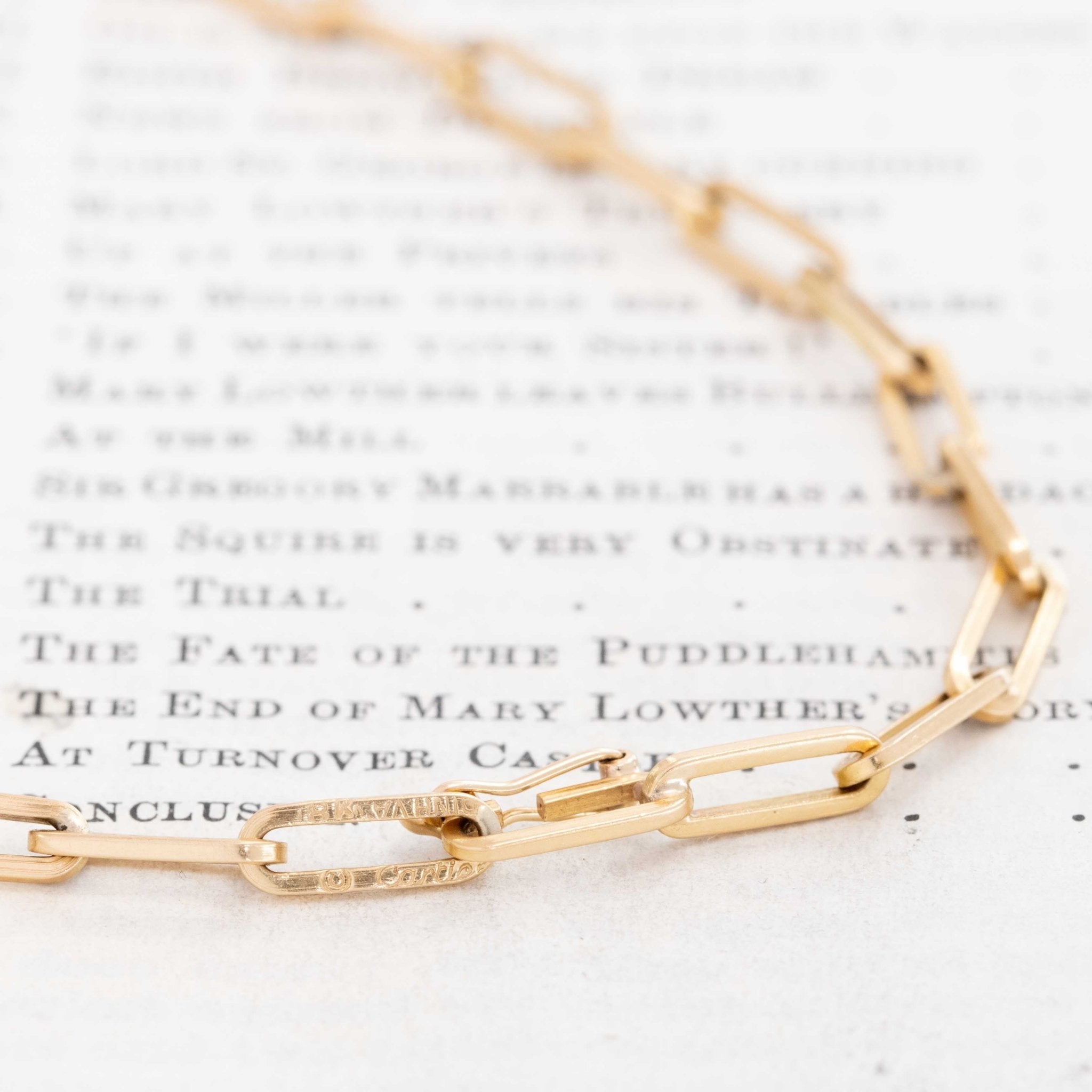 Close-up of Cartier Dinh Van yellow gold paperclip link chain showing minimalist modern design