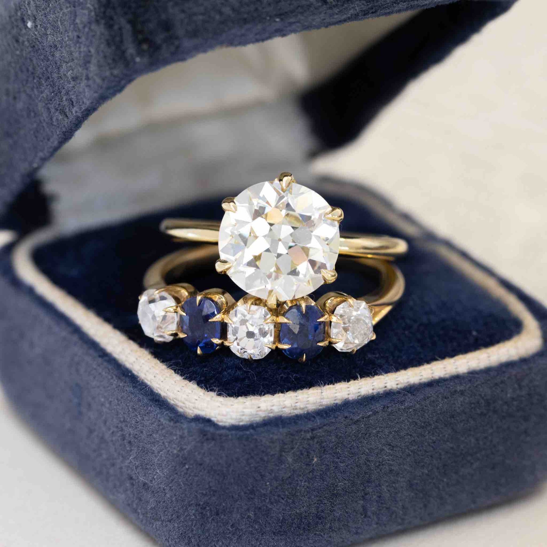 3.02ct transitional cut diamond solitaire ring paired with a five-stone band featuring alternating sapphires and old mine cut diamonds