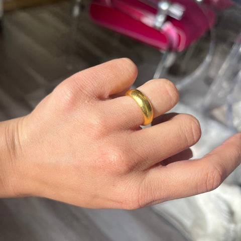 vintage 24kt wide gold wedding band on finger