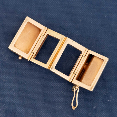 Novelty gold accordion locket charm with engraved key details and hinged photo compartments.