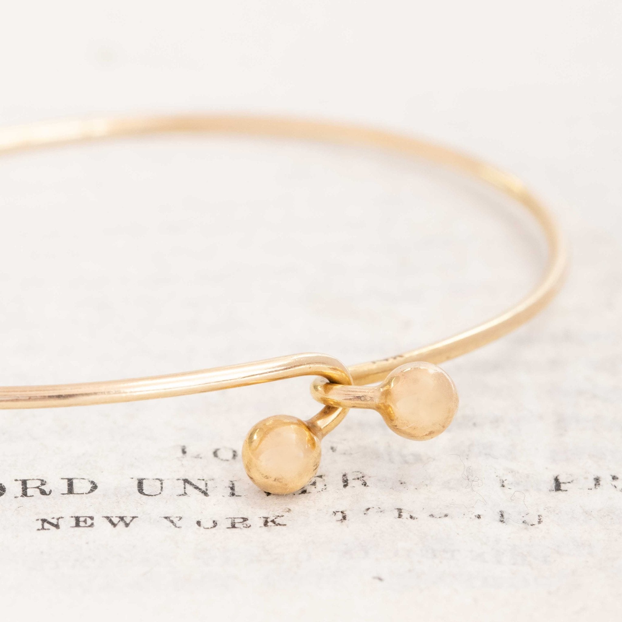 Yellow gold vintage bangle resting on book