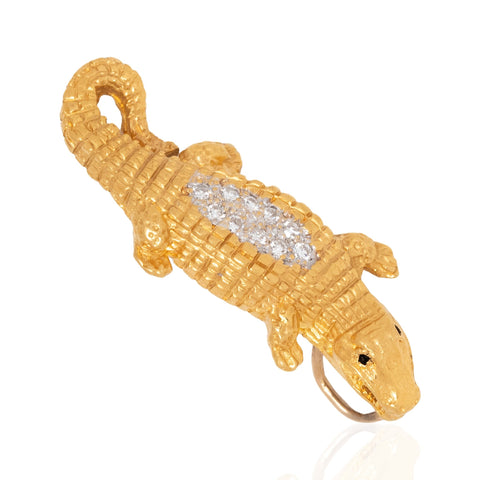 A gold alligator or crocodile-shaped pendant with a textured scale finish and a row of clear pavé stones across the back, shown on a white background.