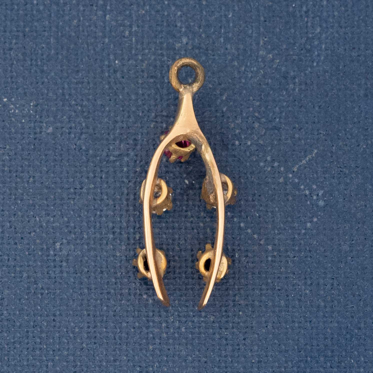 Small gemstone wishbone charm with ruby, diamonds, and sapphires