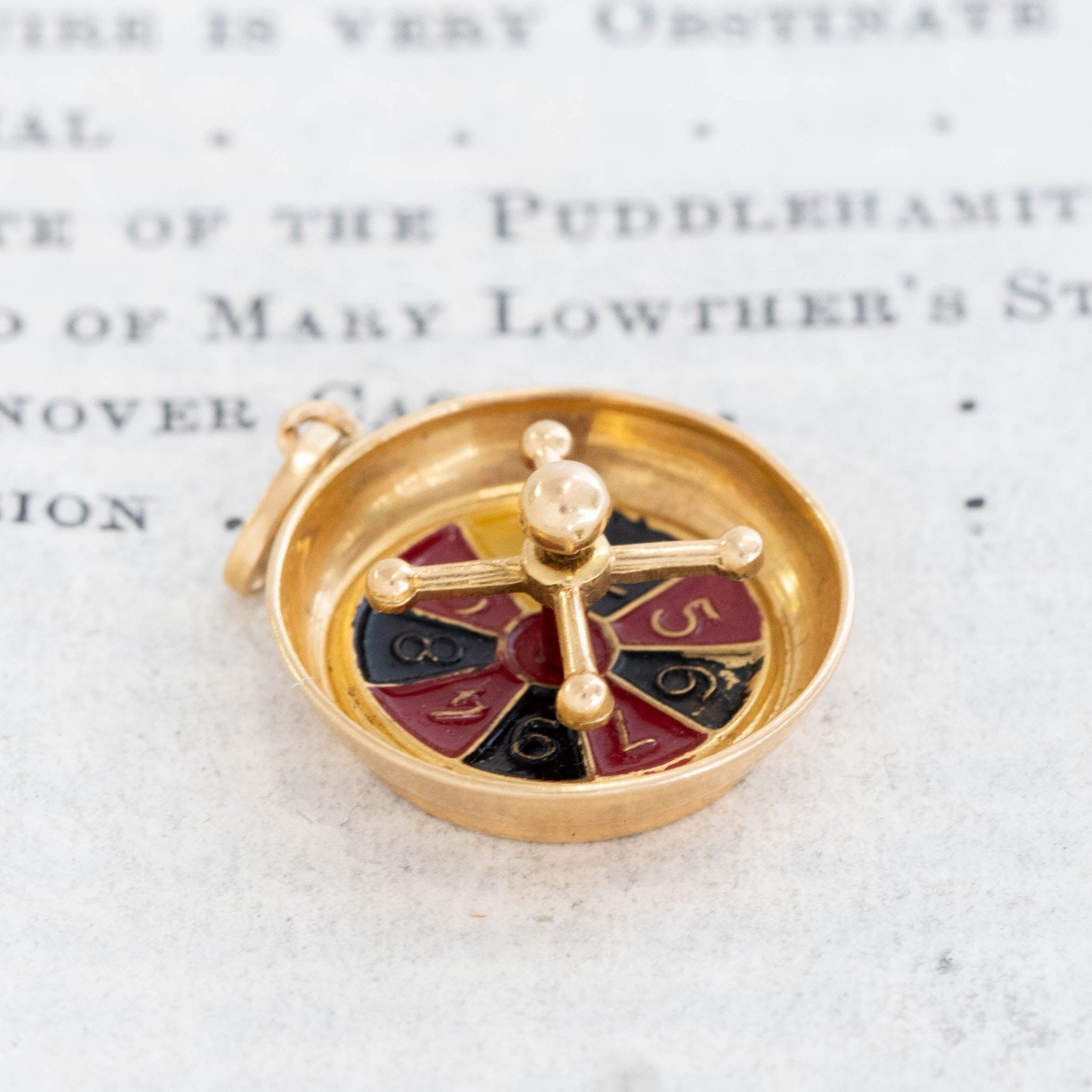 Gold roulette wheel charm inspired by French casino jewelry