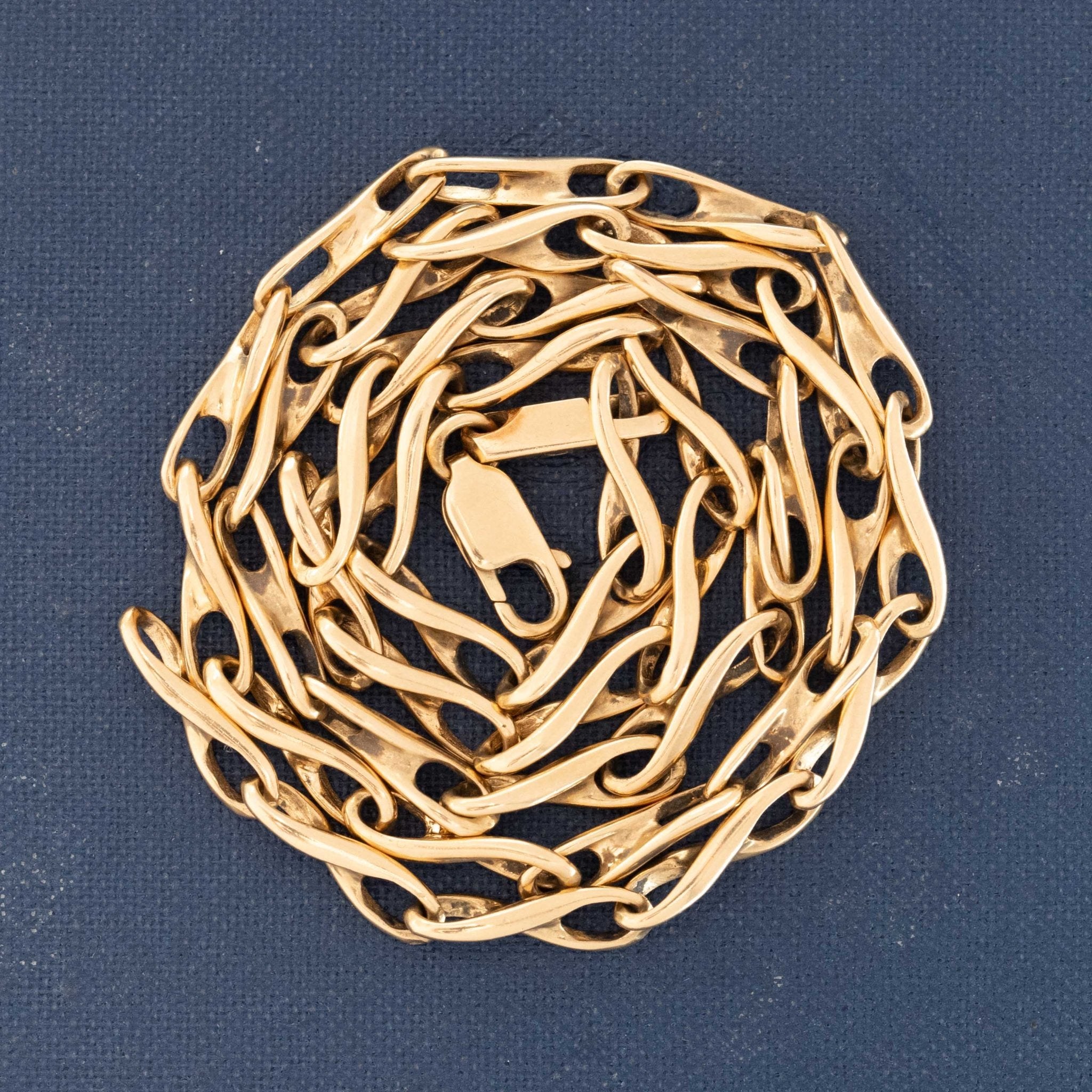 Gold chain necklace on a blue background