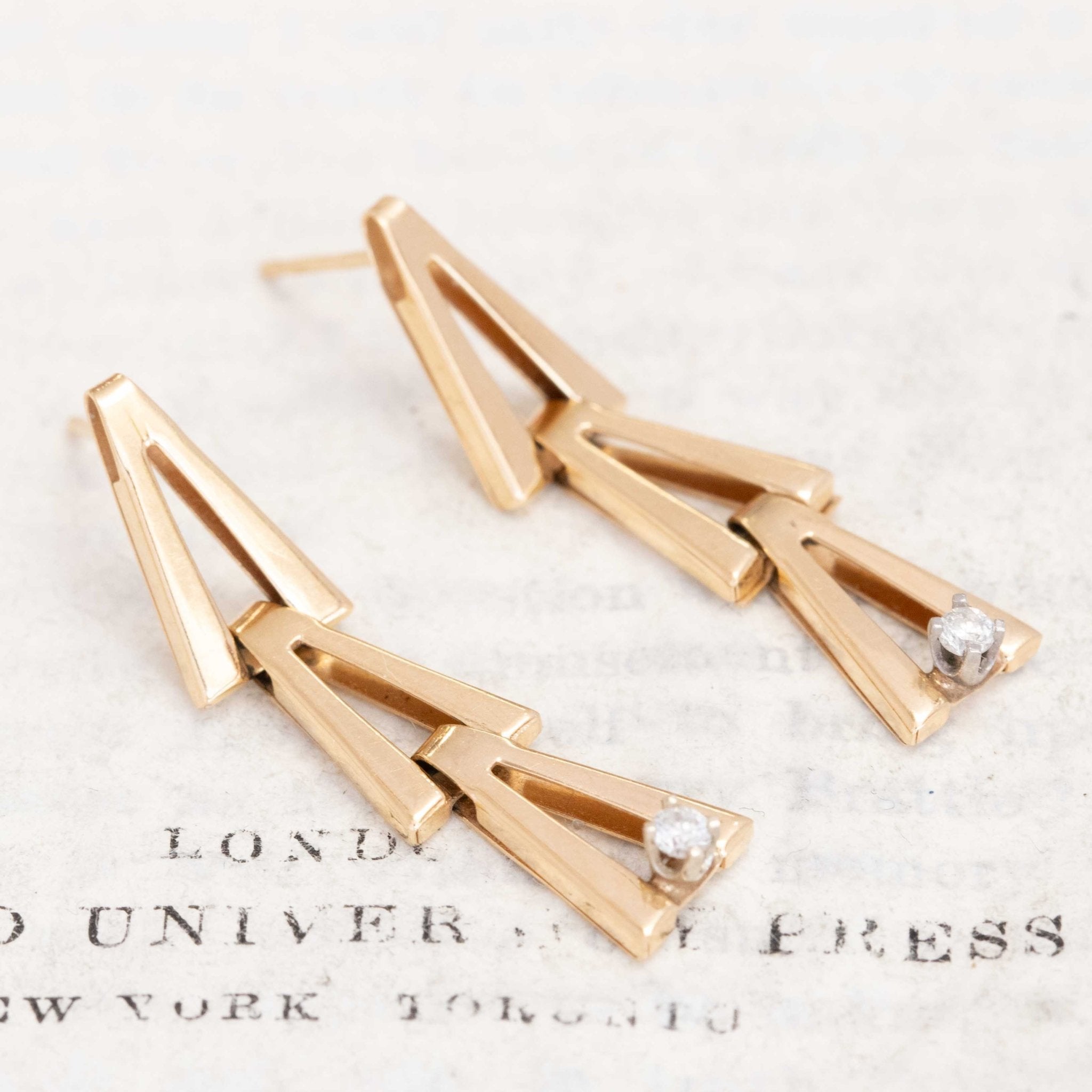 Pair of modern yellow gold V-link earrings with sparkling baby diamonds at the base.
