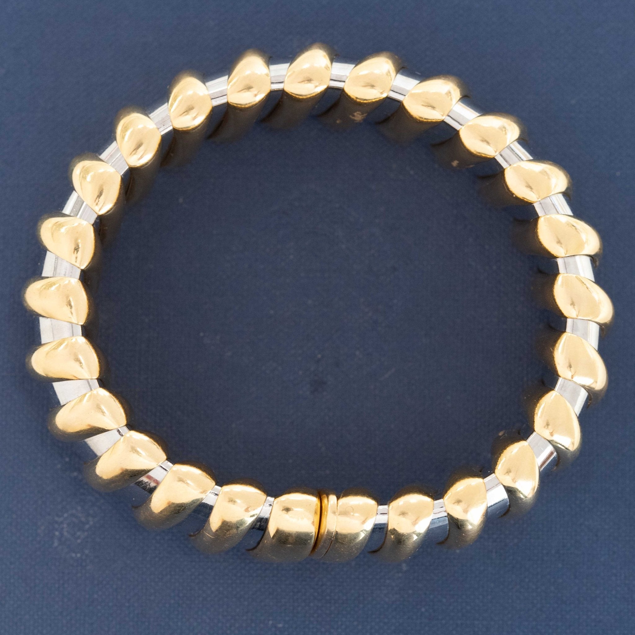 Gold and silver bracelet on a dark blue background