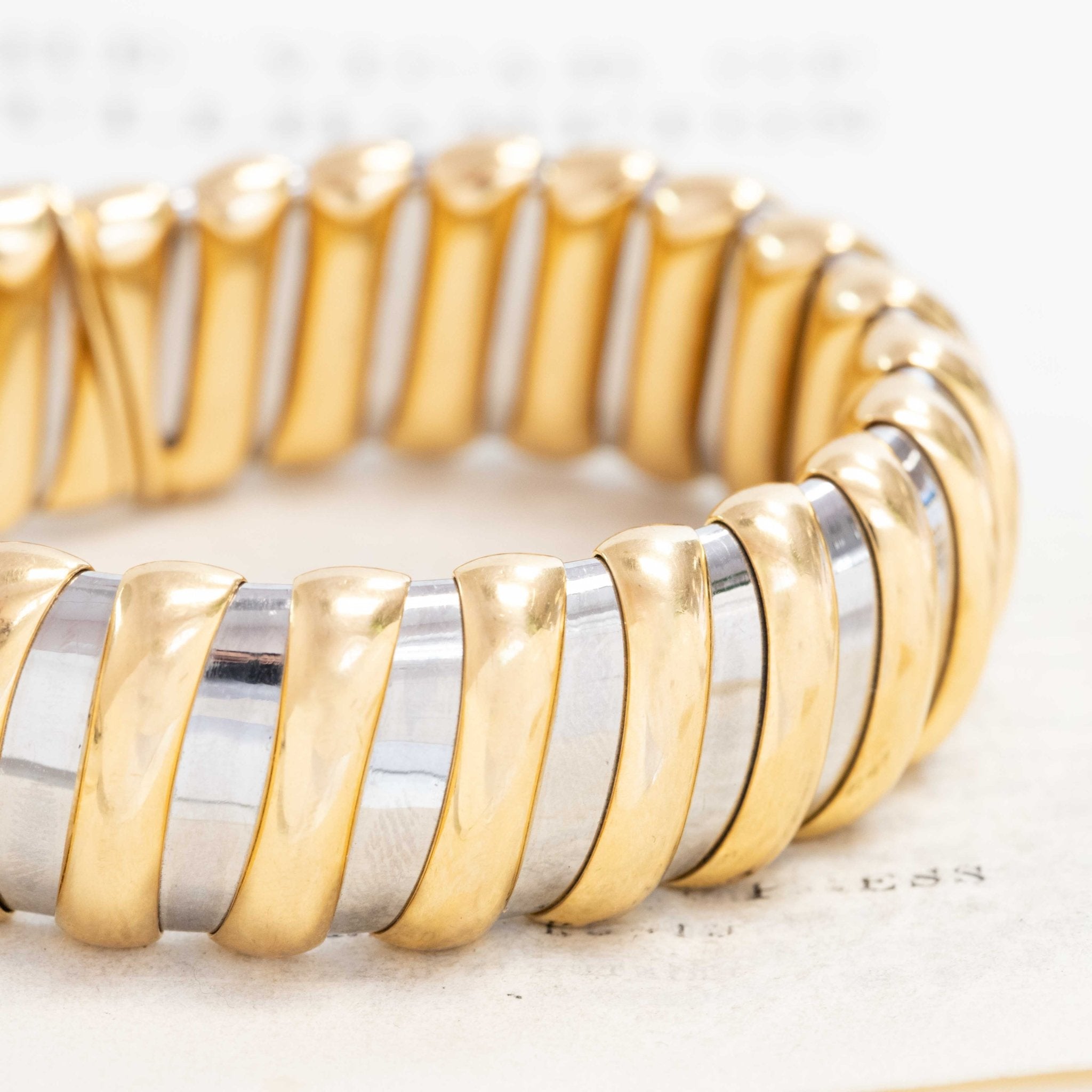 Bulgari two-tone 18k Tubogas bracelet on neutral background”