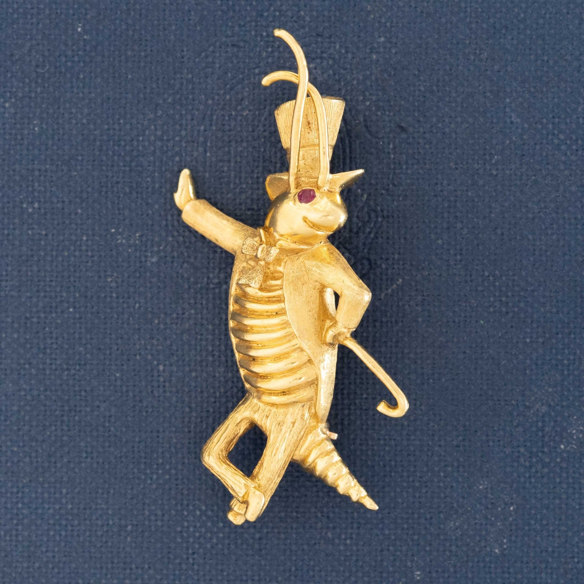 Playful vintage gold insect character brooch. Gold Jiminy Cricket pin with cane and bow tie detail