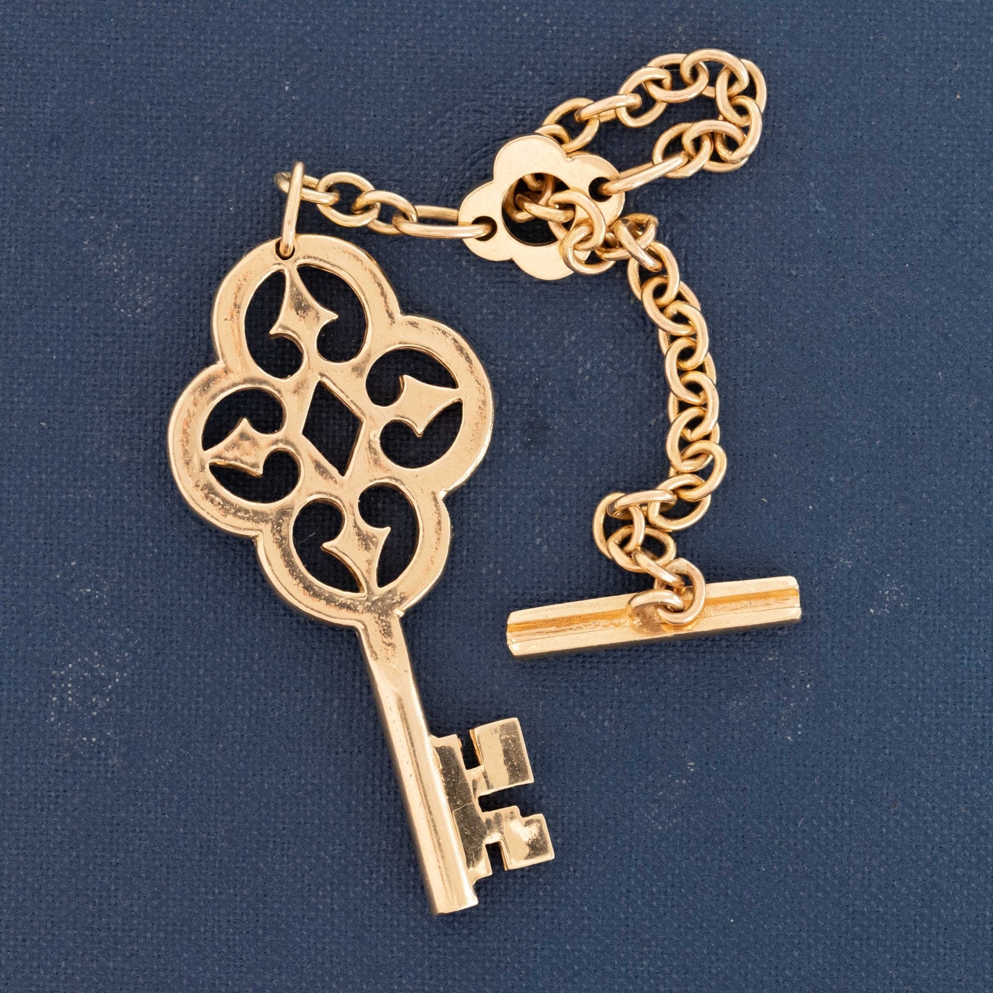 Mid-century Van Cleef & Arpels 18k gold key-shaped keychain, collectible designer accessory with elegant craftsmanship.
Van Cleef & Arpels vintage gold key charm with openwork detailing and toggle link chain, circa 1950s–1960s.